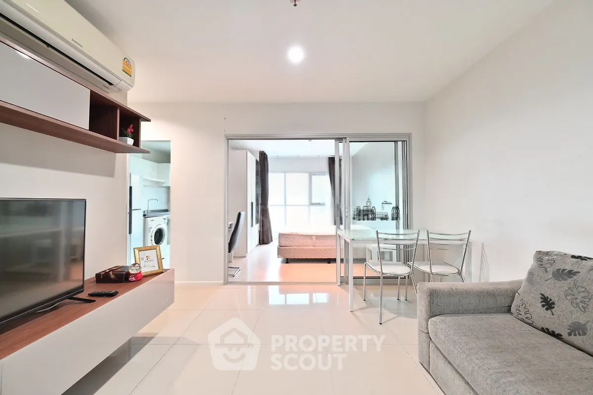 Modern living room with sleek furniture and open layout, featuring a cozy dining area and bright natural light.