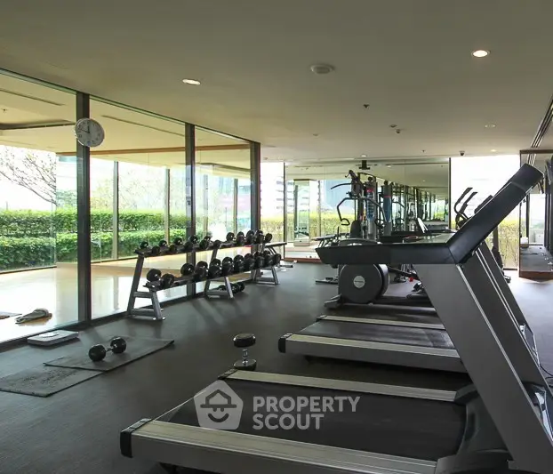Modern gym with treadmills and weights in luxury apartment complex
