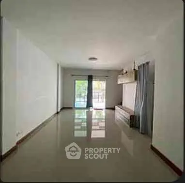 Spacious unfurnished living room with large window and glossy floor tiles