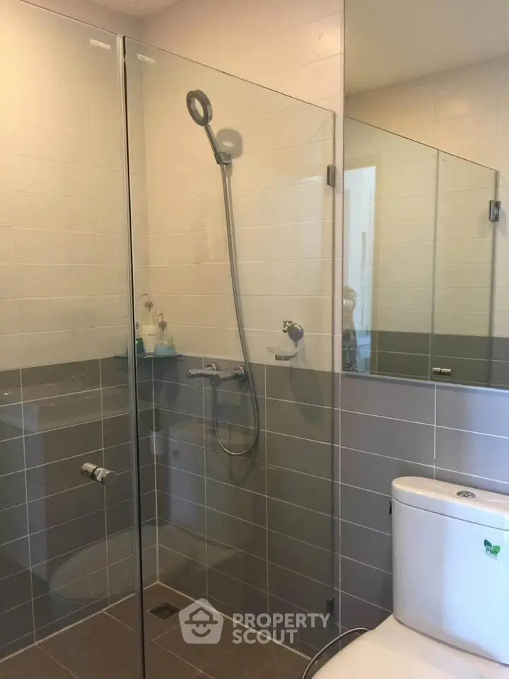 Modern bathroom with glass shower enclosure and sleek tile design.