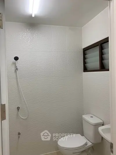 Modern bathroom with white tiles and sleek fixtures in a contemporary home.