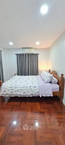 Cozy bedroom with wooden bed frame and polished hardwood floors