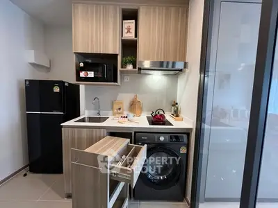 Modern compact kitchen with integrated appliances and sleek cabinetry in a stylish apartment.
