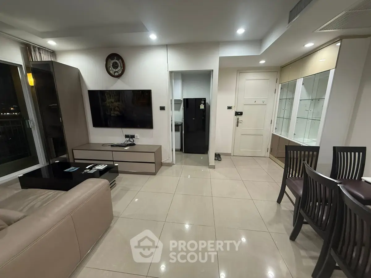 Modern living room with sleek furniture and large TV, perfect for relaxation and entertainment.