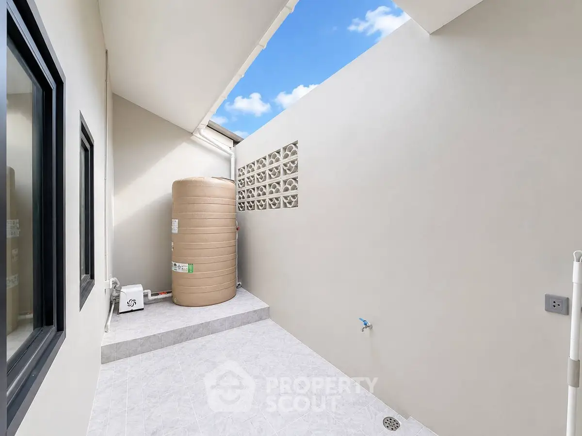 Modern outdoor utility area with water tank and bright sky view