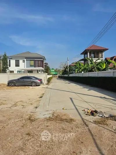 Spacious residential area with modern houses and clear blue sky, perfect for family living.