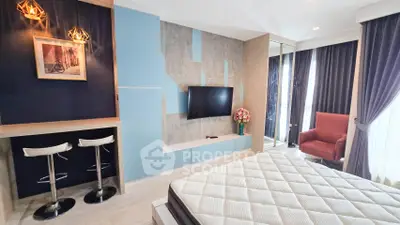 Modern bedroom with stylish decor, wall-mounted TV, and cozy seating area.