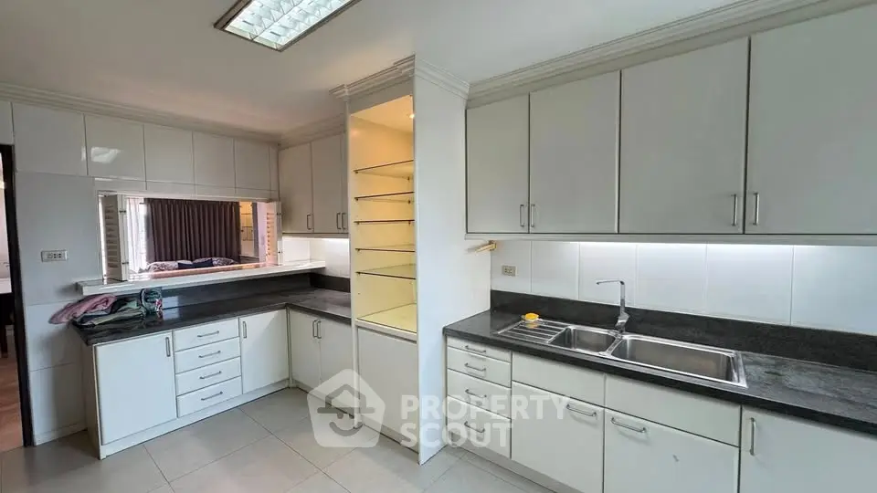 Spacious kitchen with ample cabinetry and dual sink in modern apartment