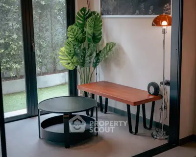 Modern interior with stylish furniture and lush greenery view.