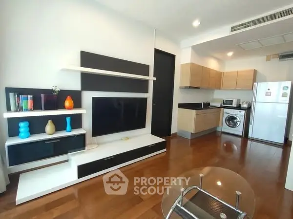 Modern open-plan living room with sleek kitchen and stylish shelving unit.