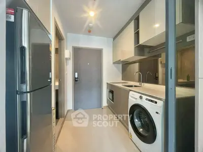 Modern kitchen with sleek appliances and washing machine in compact layout.