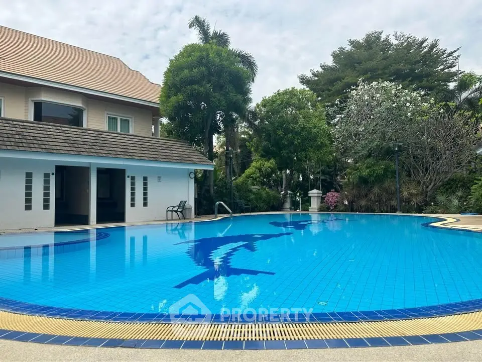 Luxurious residential pool area with tropical landscaping and elegant architecture.