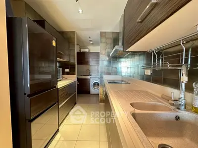 Modern kitchen with sleek appliances and washing machine in stylish apartment.