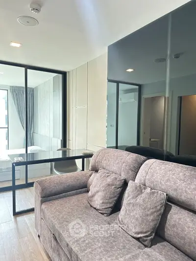 Modern living room with stylish sofa and glass partition in a contemporary apartment.