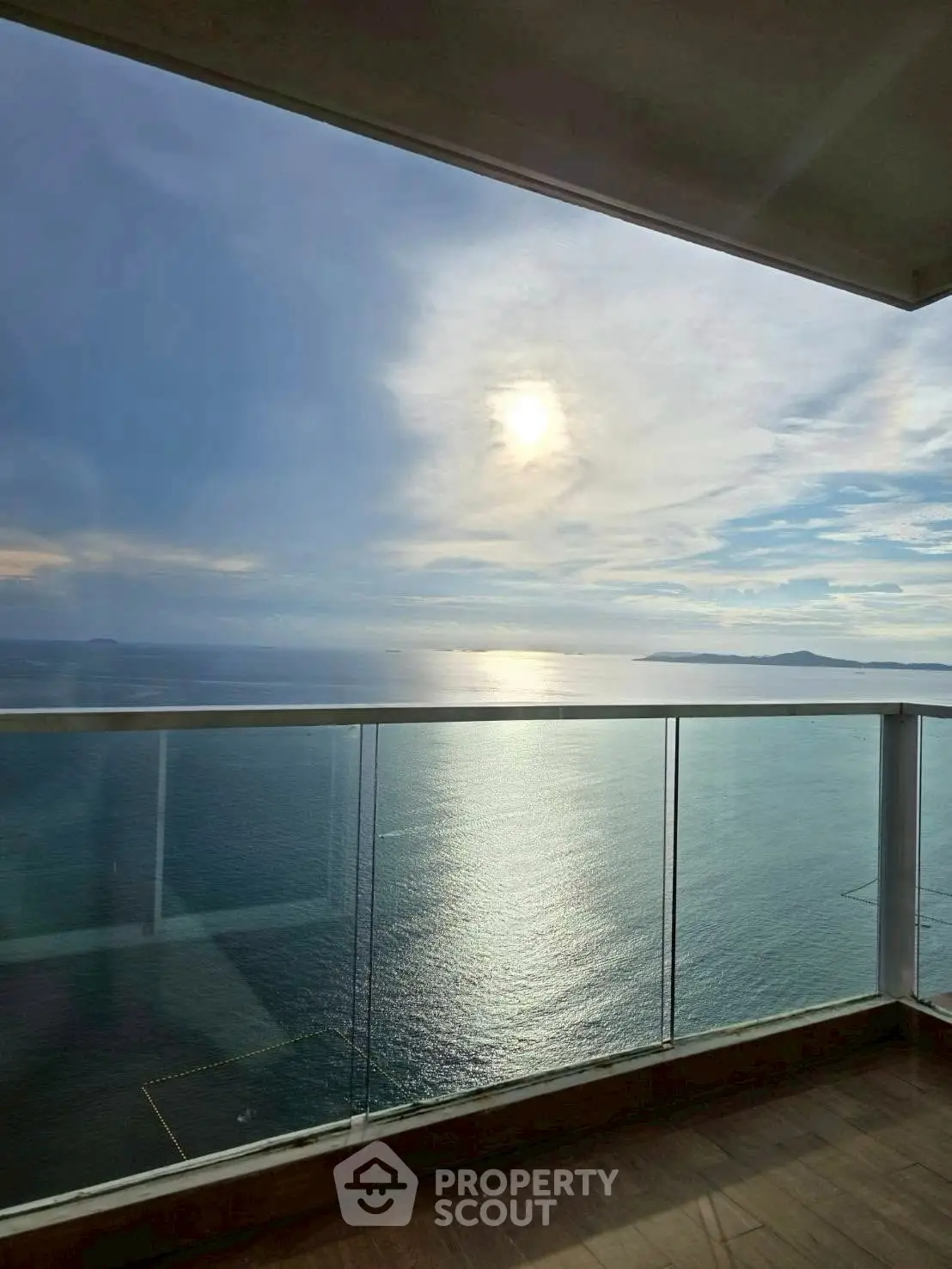 Stunning ocean view from a modern balcony with glass railing, perfect for serene living.