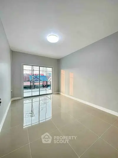 Spacious empty room with large windows and glossy tiled floor, perfect for customization.
