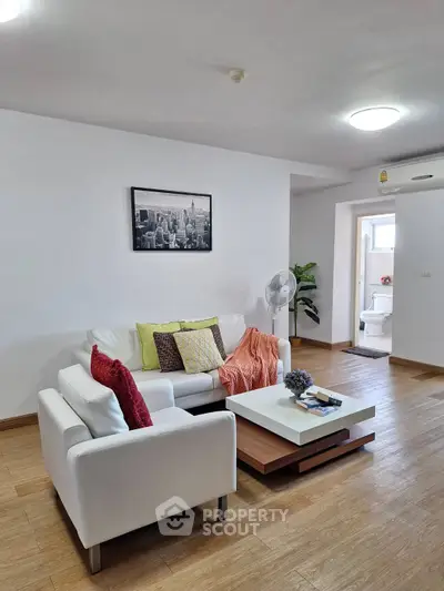 Modern living room with stylish white furniture and wooden flooring
