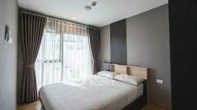 Modern bedroom with large window and elegant curtains in a stylish apartment.