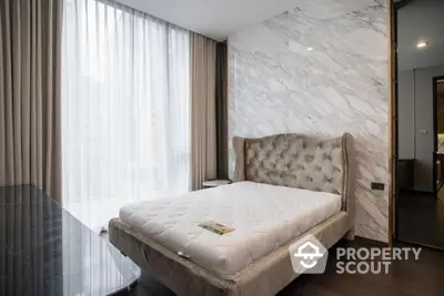 Luxurious bedroom with elegant marble accent wall and plush bed in modern apartment