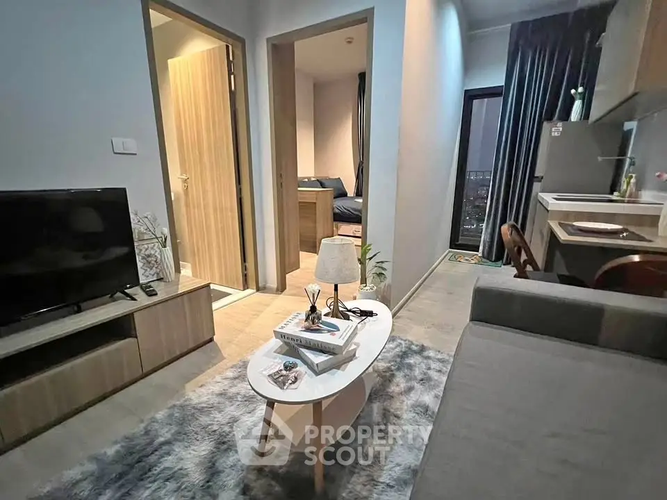 Modern apartment living room with cozy decor and open kitchen layout.