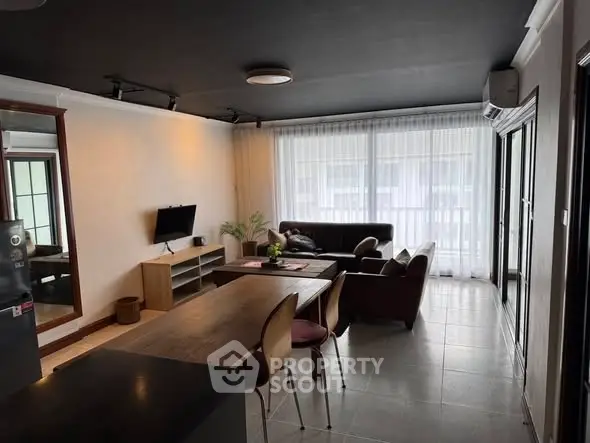 Spacious modern living room with dining area and large windows for natural light.