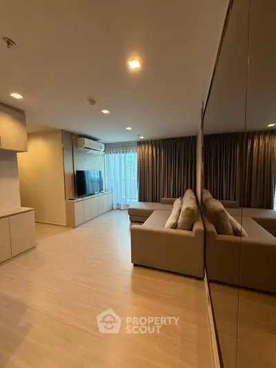 Spacious modern living room with large sofa and entertainment center, ideal for relaxation.