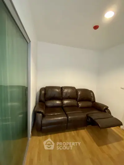 Cozy living room with leather recliner sofa and wooden flooring