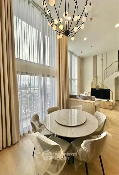 Luxurious modern living room with high ceilings and elegant chandelier