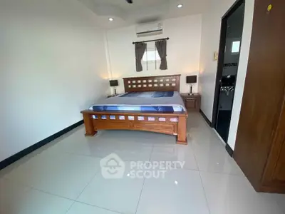 Spacious bedroom with modern furnishings and air conditioning in a stylish apartment.