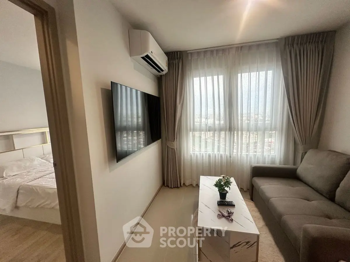 Modern living room with sleek furniture and large windows offering natural light.