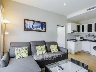 Modern living room with stylish sofa and open kitchen layout in a cozy apartment.