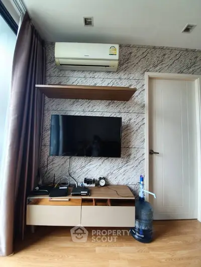 Modern living room corner with wall-mounted TV and air conditioning