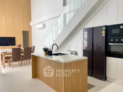 Modern open kitchen with sleek design and dining area in stylish apartment