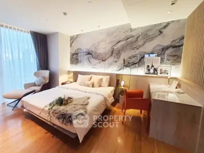 Luxurious modern bedroom with elegant marble accent wall and cozy furnishings.