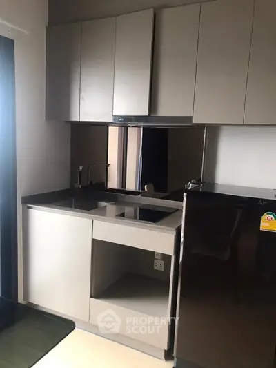 Modern compact kitchen with sleek cabinetry and stainless steel appliances
