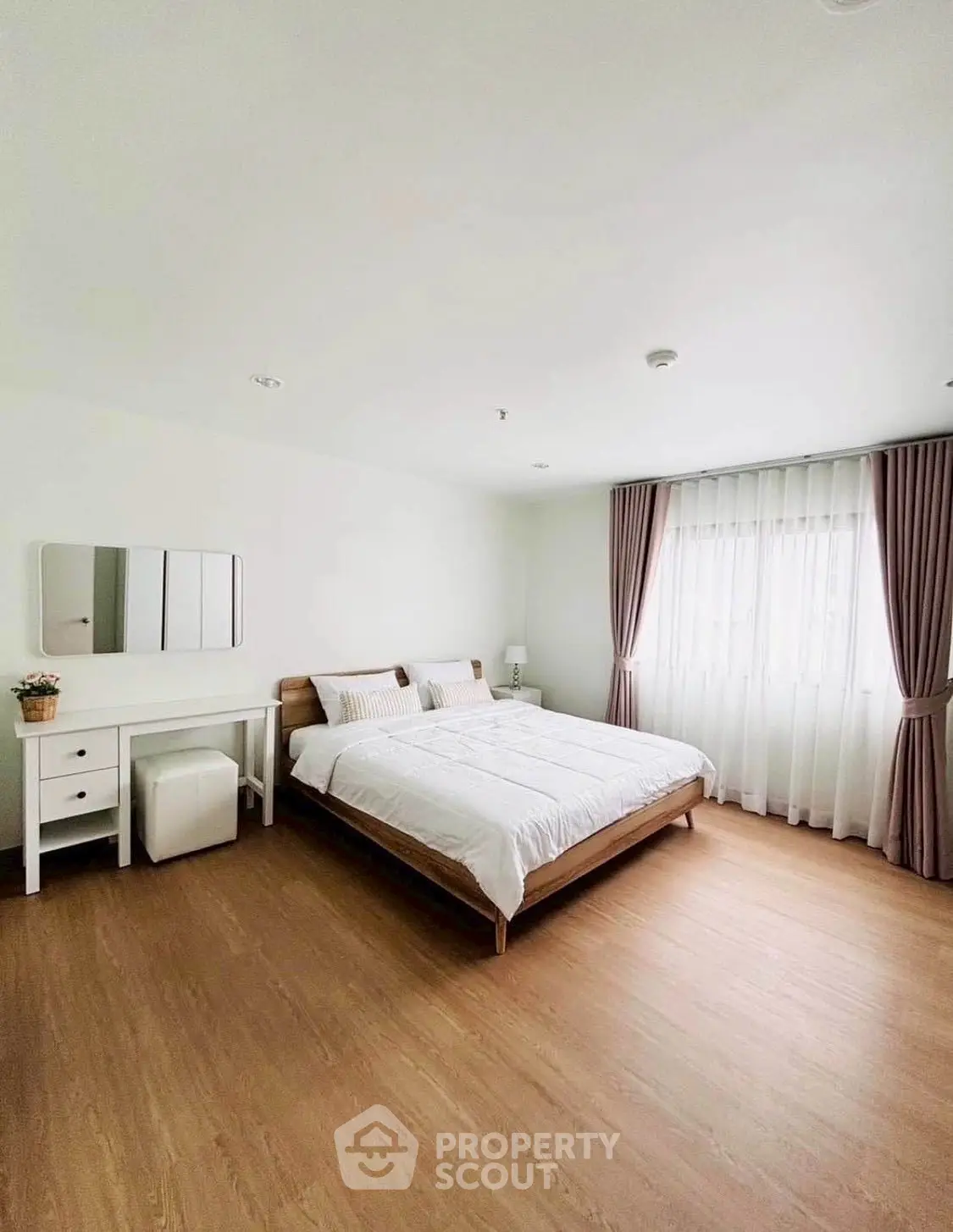 Spacious bedroom with minimalist decor and natural light
