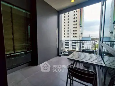 Modern balcony with city view and outdoor seating area.