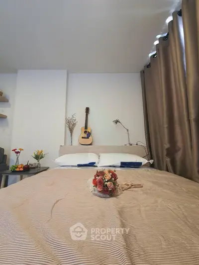 Cozy bedroom with elegant decor and guitar on wall, perfect for relaxation.