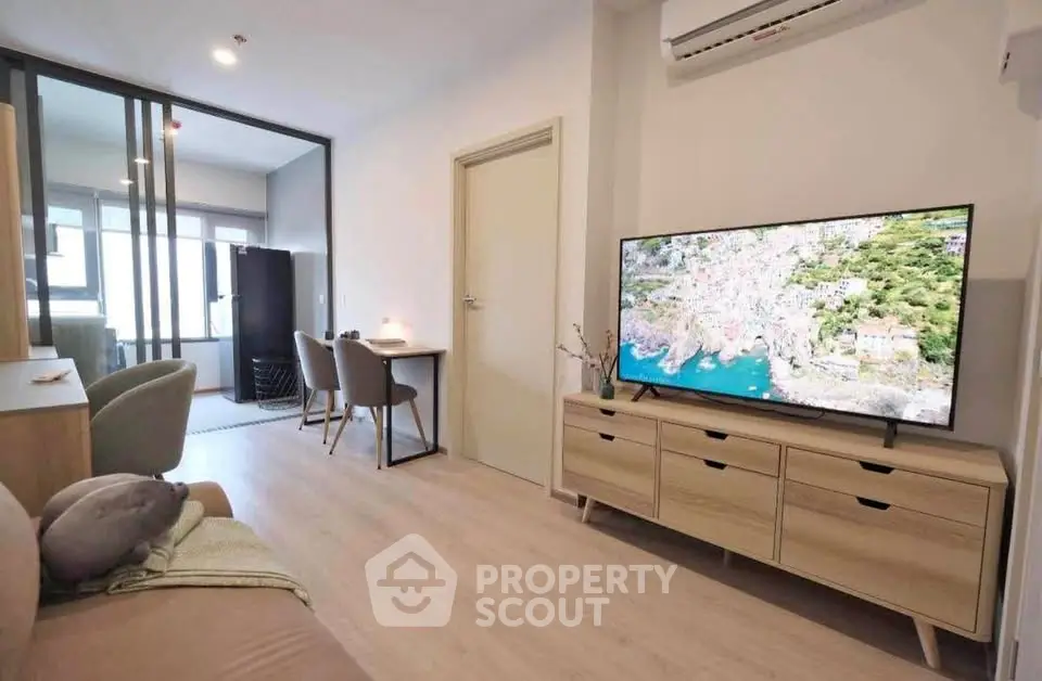 Modern living room with sleek furniture and large TV, perfect for relaxation and entertainment.