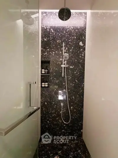 Luxurious modern bathroom with sleek marble shower and contemporary fixtures.