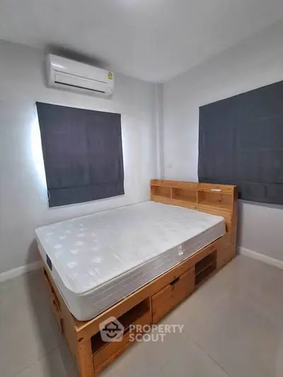 Cozy bedroom with built-in storage bed and air conditioning, perfect for modern living.