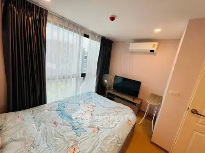 Cozy bedroom with large window, air conditioning, and modern decor in a stylish apartment.