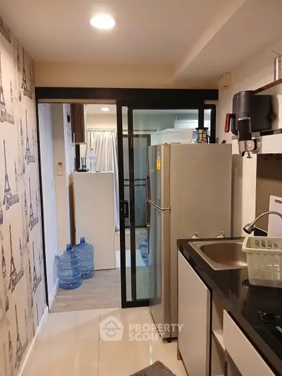 Compact kitchen with modern appliances and Eiffel Tower wallpaper