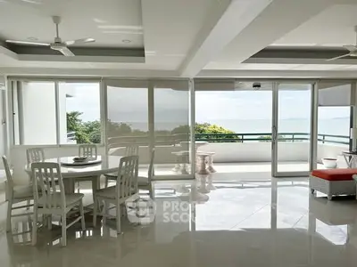Spacious living room with ocean view and large balcony access, perfect for relaxation and entertaining.