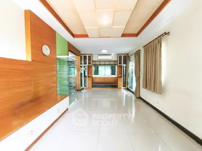 Spacious modern living room with elegant wooden accents and large windows for natural light.
