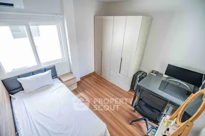 Cozy bedroom with modern furniture and workspace, ideal for comfortable living.