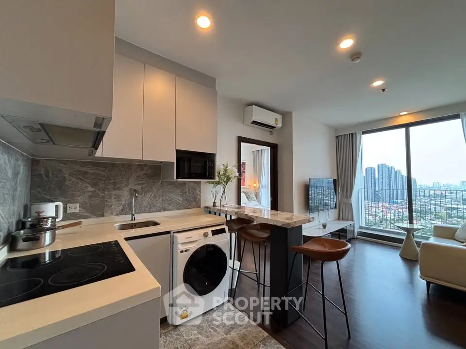 Modern open-plan kitchen and living room with city view in high-rise apartment