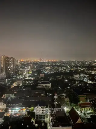 Stunning cityscape view from high-rise building at night, showcasing vibrant urban lights.