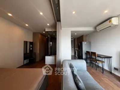 Modern studio apartment with open layout, featuring a cozy living area, compact kitchen, and stylish furnishings.