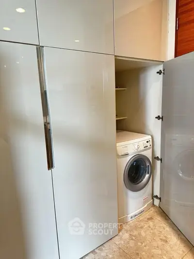 Modern laundry area with built-in washing machine in sleek cabinetry